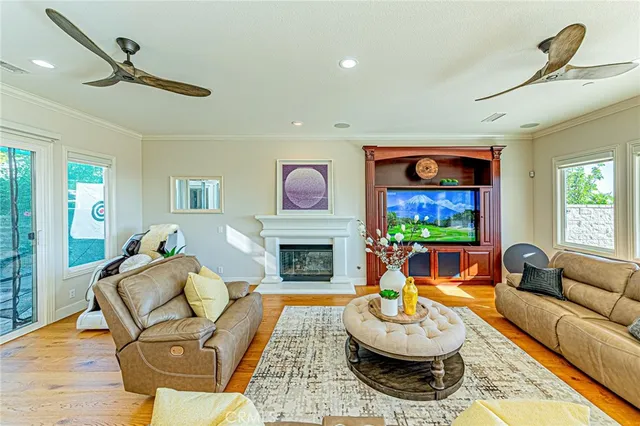 a living room with furniture a flat screen tv and a floor to ceiling window