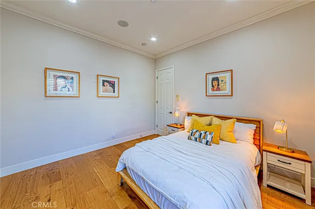 a spacious bedroom with a large window and a table chair