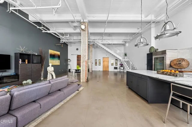 a living room with lots of furniture and a kitchen view