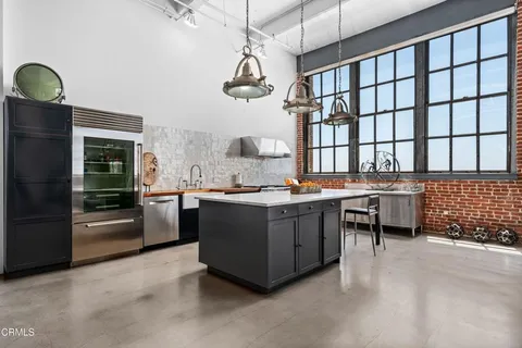 a kitchen with stainless steel appliances granite countertop a stove a sink and a refrigerator