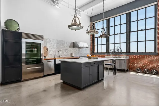 a kitchen with stainless steel appliances granite countertop a stove a sink and a refrigerator