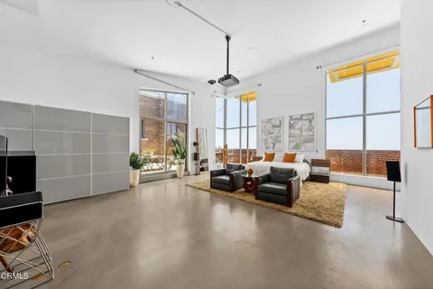 a living room with furniture a chandelier a fireplace and a flat screen tv