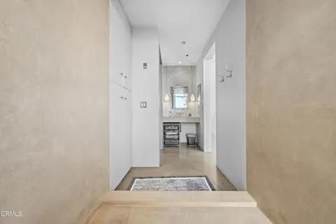 an entryway with a cabinet and a rug