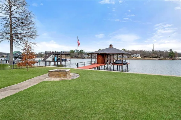 a view of a lake with a table and chairs under an umbrella