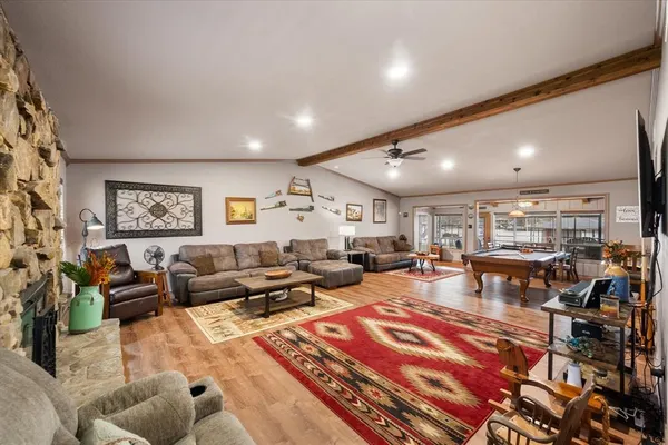 a living room with lots of furniture and view of kitchen
