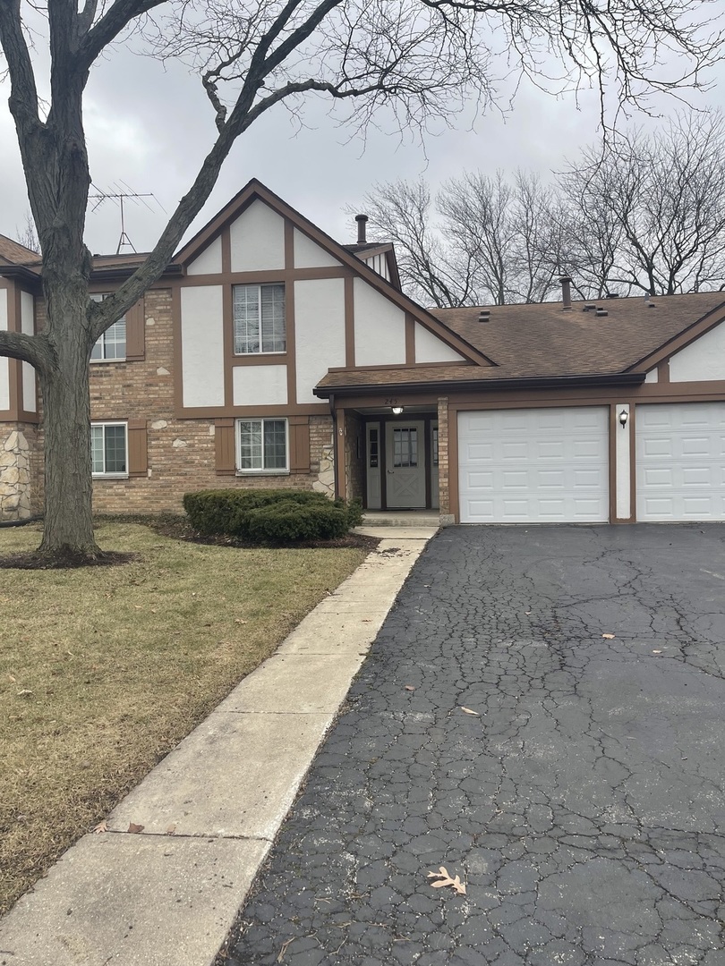 245 Memory Lane, Unit 3 Westmont, IL 60559 - Photo 1 of 28 a front view of a house with a yard and potted plants