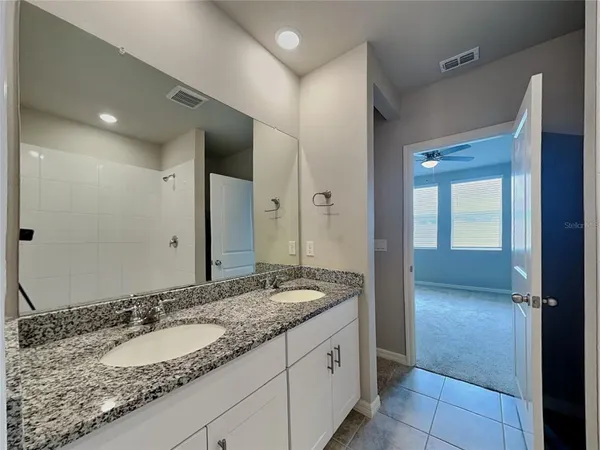 a bathroom with a granite countertop sink and a mirror
