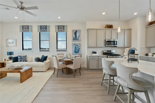 a living room with furniture a rug kitchen view and a window