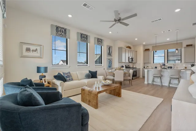 a living room with furniture kitchen view and a chandelier