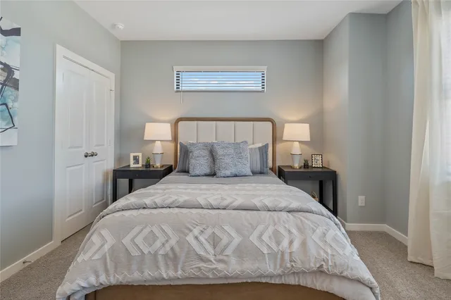 a large bed sitting in a bedroom next to a window