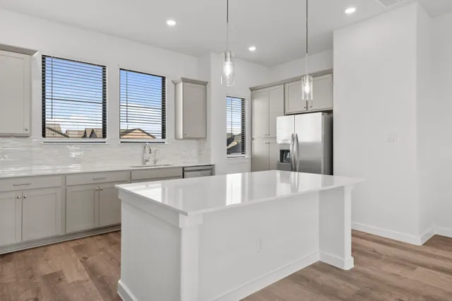 a kitchen with stainless steel appliances granite countertop a refrigerator a sink and a refrigerator