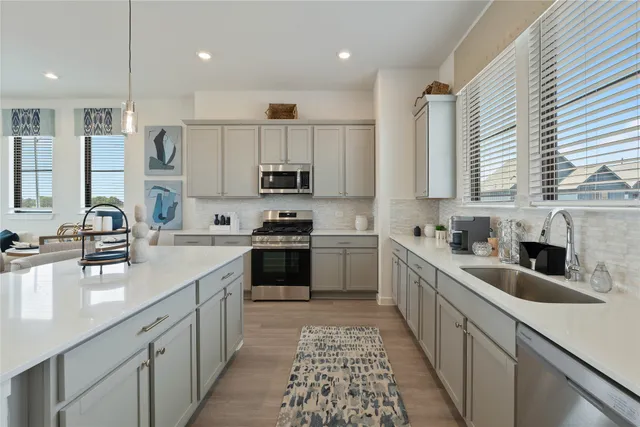 a kitchen with kitchen island granite countertop a sink stainless steel appliances and cabinets