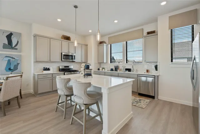 a kitchen with kitchen island granite countertop a sink cabinets and wooden floor