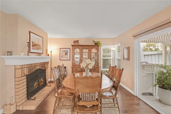 a dining room with furniture a fireplace and wooden floor