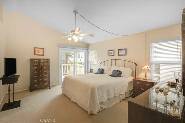 a bedroom with a large bed and a flat tv screen on dresser