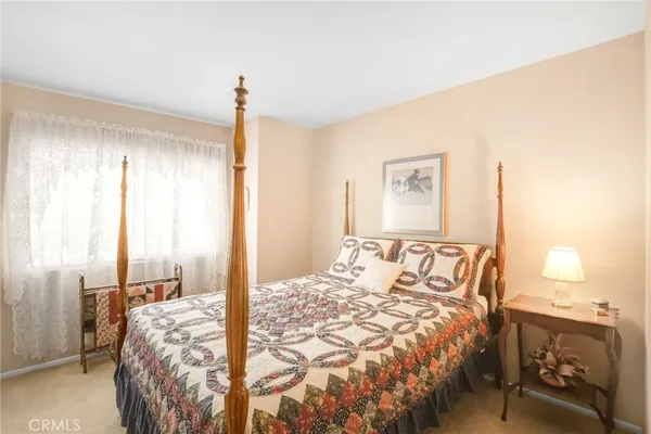 a bedroom with a large bed and a chandelier