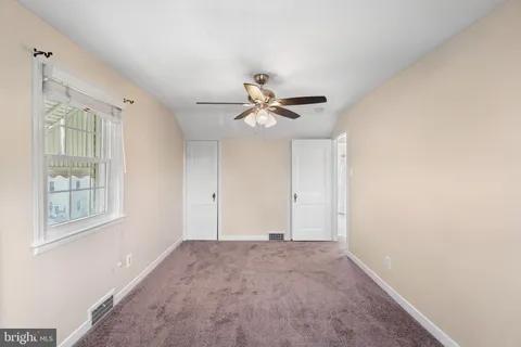 a view of a livingroom with a ceiling fan and window