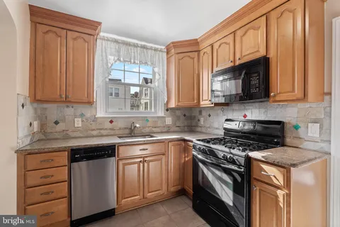 a kitchen with stainless steel appliances granite countertop a sink stove and microwave