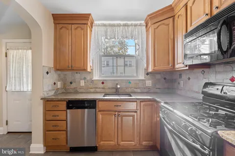 a kitchen with stainless steel appliances granite countertop a sink and a stove