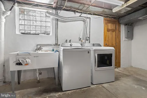 a utility room with sink dryer and washer