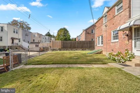a view of swimming pool with outdoor seating and house in the background