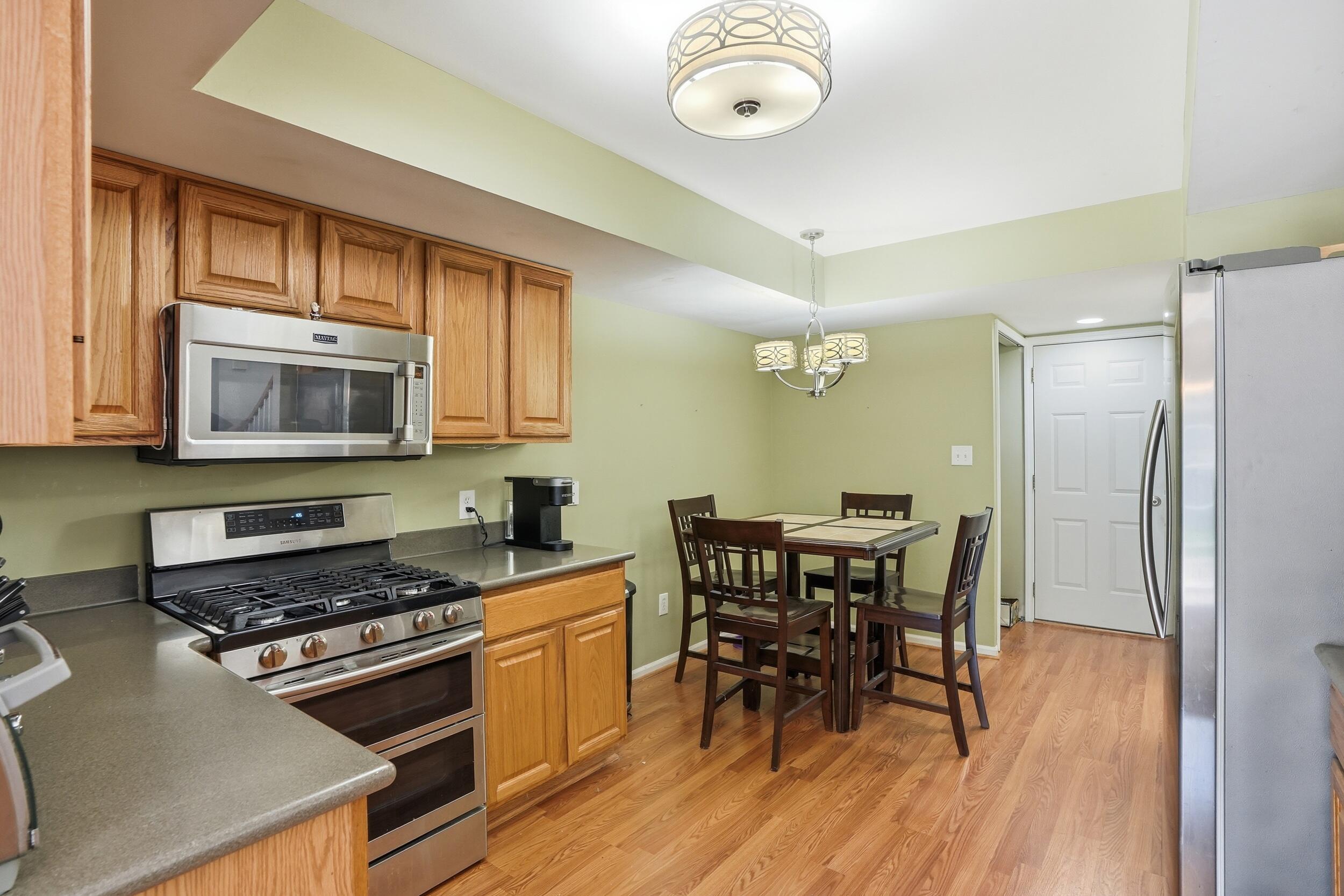 2184 Timberidge Lane Highland, IN 46322 - Photo 7 of 18 a kitchen with stainless steel appliances a dining table chairs and stove