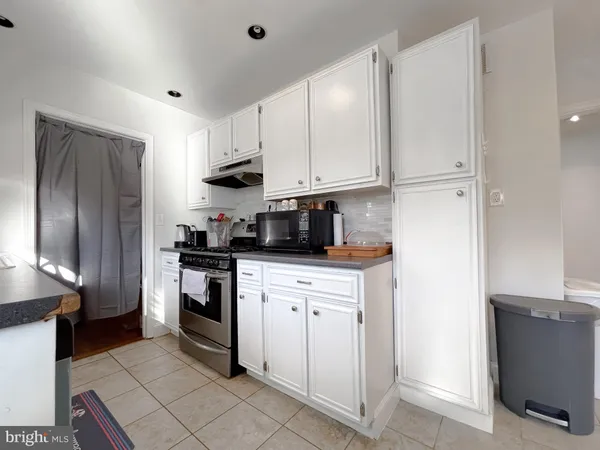 a kitchen with cabinets stainless steel appliances and a counter space