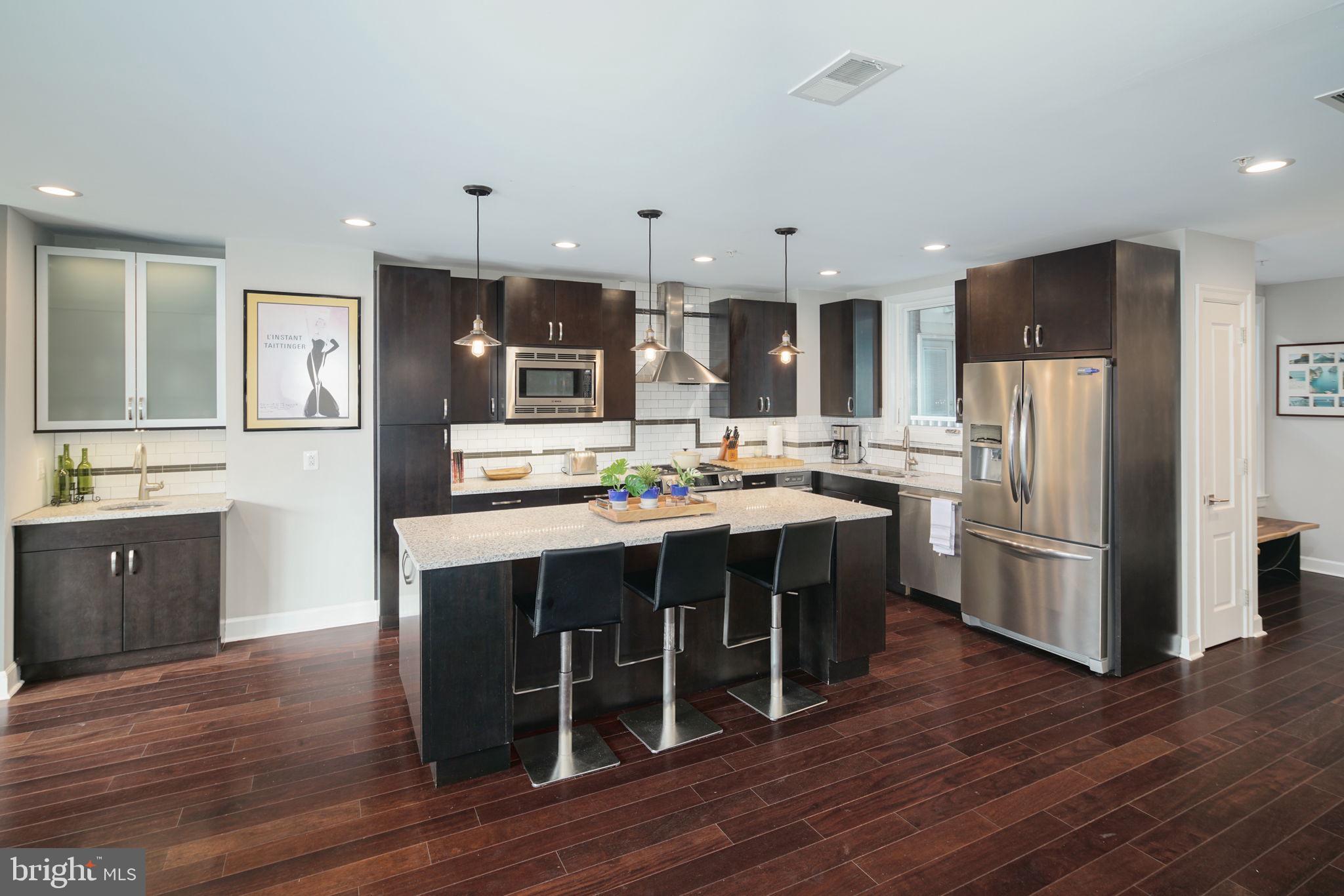 1910 Spring Garden Street, Unit 2 Philadelphia, PA 19130 - Photo 4 of 36 a kitchen with kitchen island wooden cabinets and stainless steel appliances