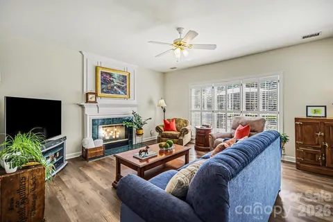 a very nice looking kitchen with granite countertop a stove a sink a dining table and chairs with wooden floor