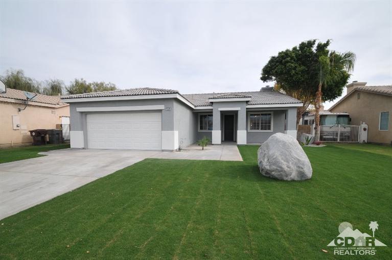 a front view of a house with a garden and yard