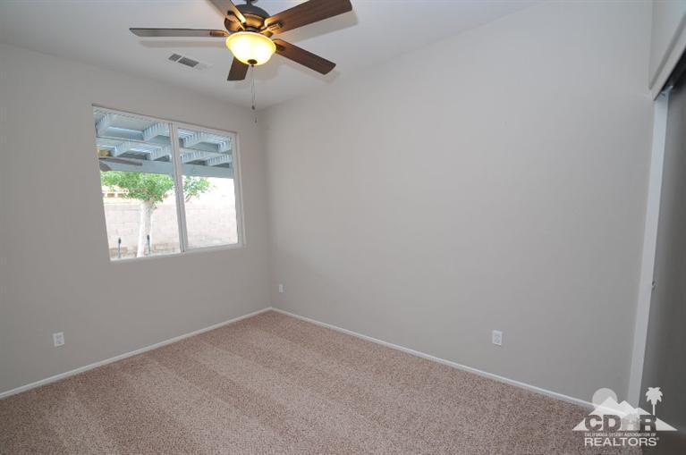 47534 Stampede Trail Indio, CA 92201 - Photo 11 of 17 an empty room with a window and a fan