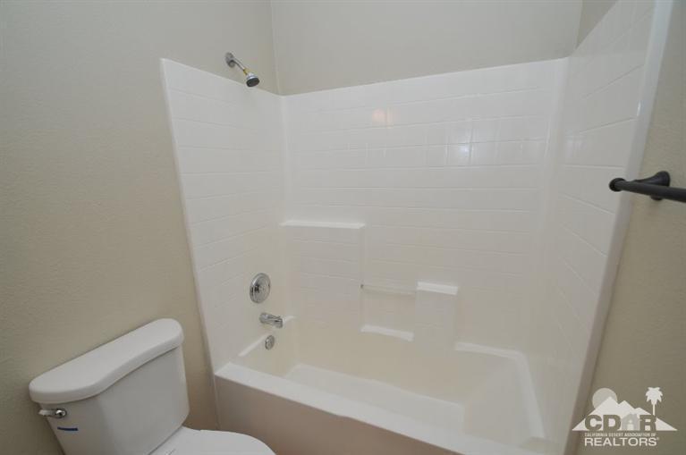 47534 Stampede Trail Indio, CA 92201 - Photo 7 of 17 a bathroom with a bathtub a toilet and a shower