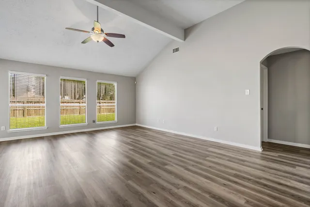 a view of a room with wooden floor and a ceiling fan
