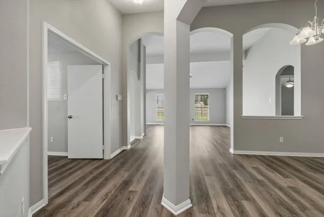 a view of empty room with wooden floor