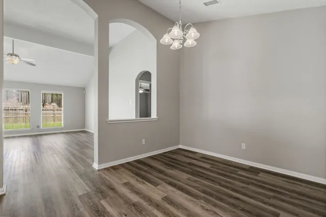 a view of a room with wooden floor and chandelier