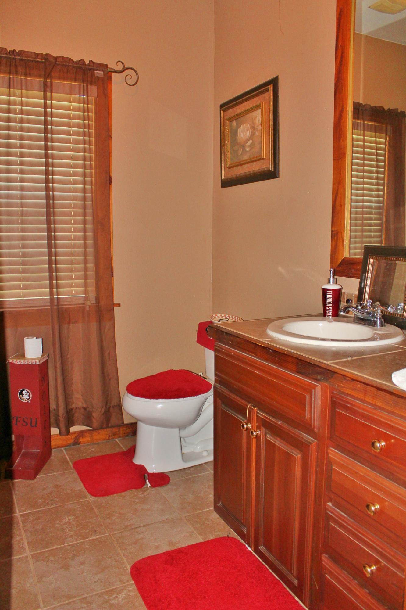 2913 King Lake Road DeFuniak Springs, FL 32433 - Photo 26 of 31 a bathroom with a toilet sink and mirror
