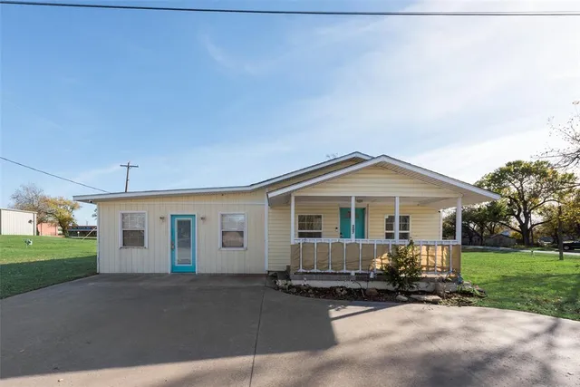 a front view of a house with a garden and yard