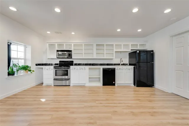 a kitchen with stainless steel appliances granite countertop a refrigerator and a stove top oven