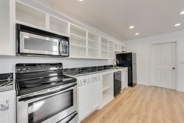 a kitchen with stainless steel appliances kitchen island granite countertop a stove and a microwave