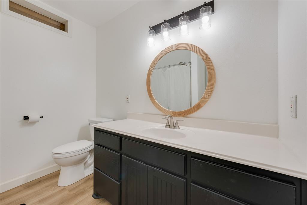 207 West Walnut Street Nocona, TX 76255 - Photo 8 of 22 a bathroom with a toilet a sink and a mirror