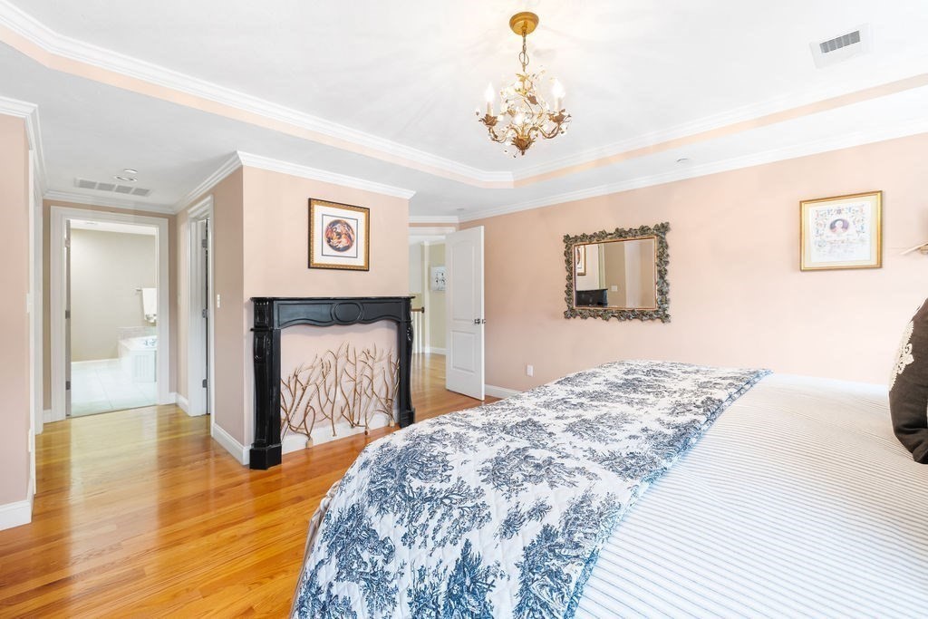 192 Boston Post Road, Unit 8 Sudbury, MA 01776 - Photo 14 of 27 a bedroom with a bed and a chandelier