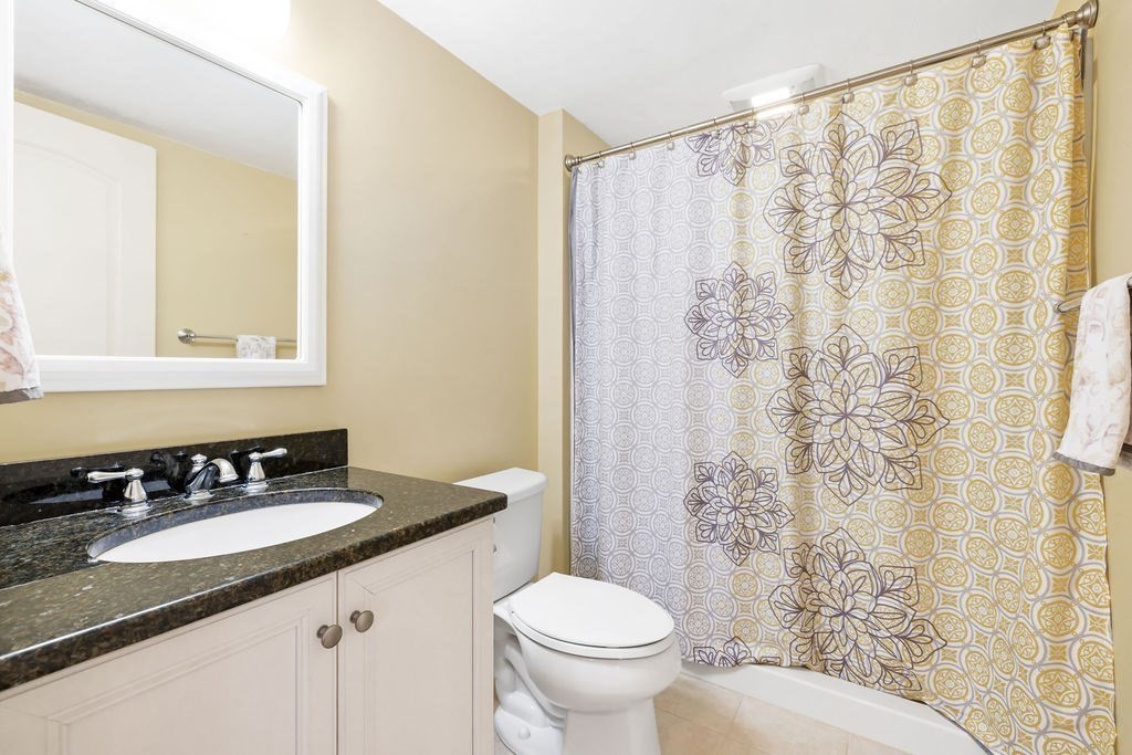 192 Boston Post Road, Unit 8 Sudbury, MA 01776 - Photo 24 of 27 a bathroom with a granite countertop sink a toilet and a mirror