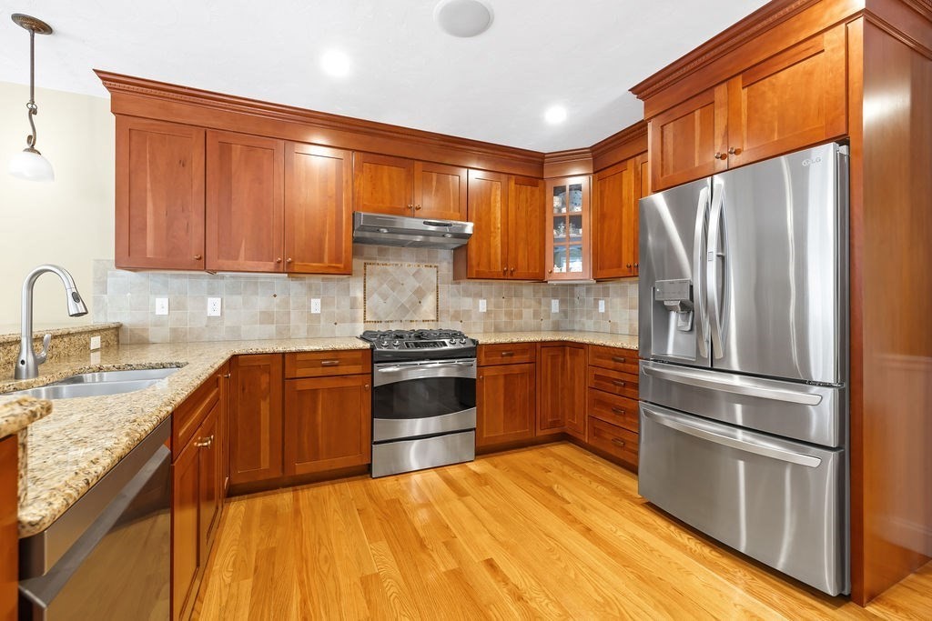 192 Boston Post Road, Unit 8 Sudbury, MA 01776 - Photo 4 of 27 a kitchen with granite countertop stainless steel appliances and wooden cabinets