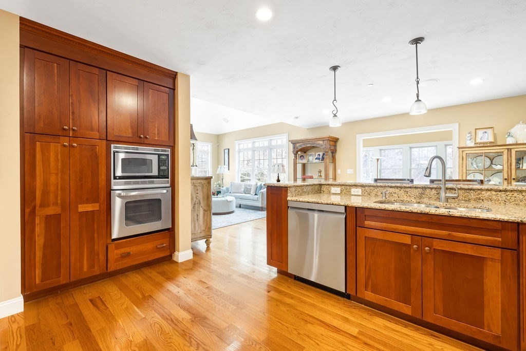 192 Boston Post Road, Unit 8 Sudbury, MA 01776 - Photo 5 of 27 a kitchen with stainless steel appliances granite countertop a refrigerator a oven and white cabinets with wooden floors
