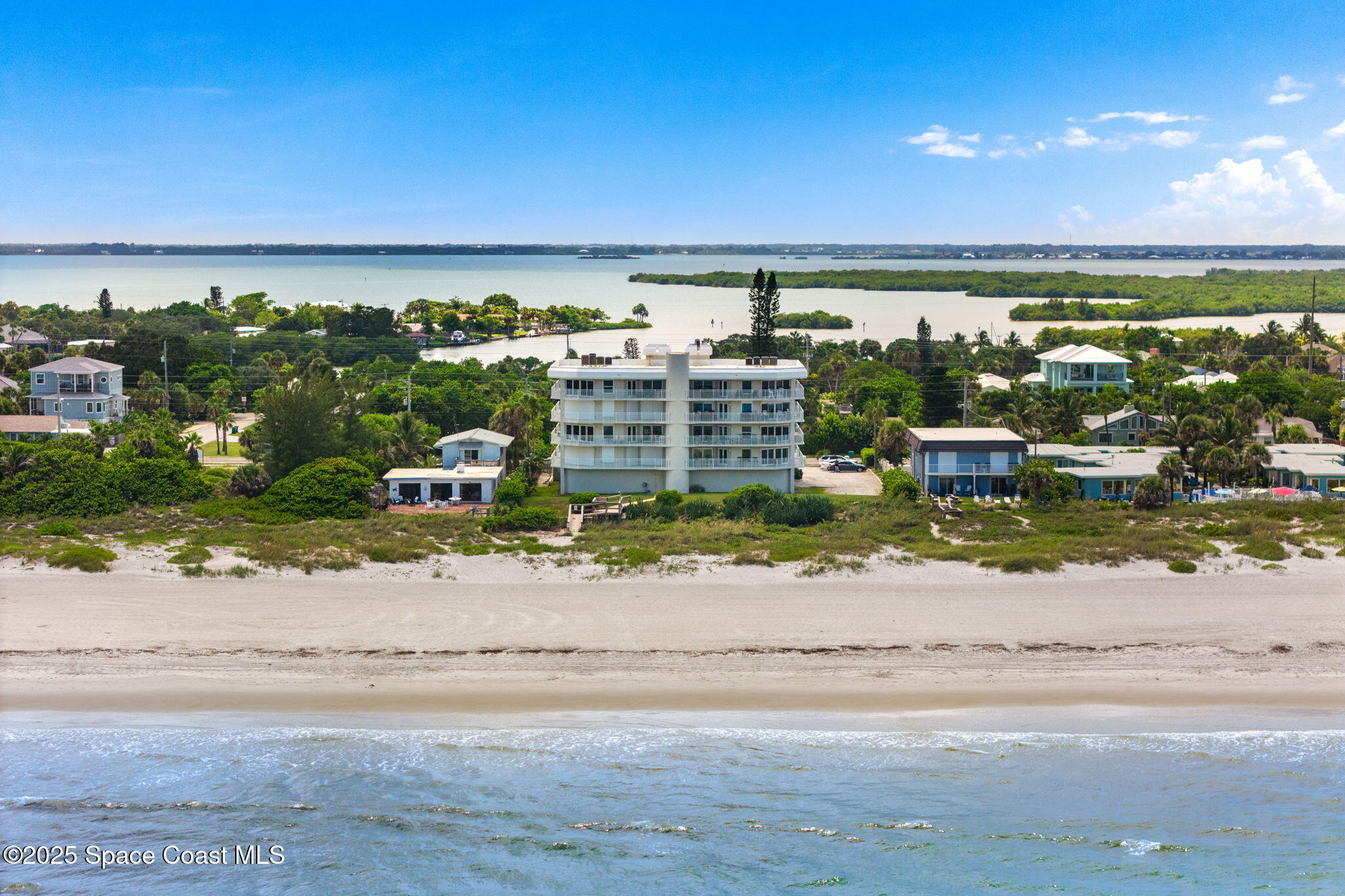 1155 South Atlantic Avenue, Unit 203 Cocoa Beach, FL 32931 - Photo 2 of 41 an ocean view with a building and trees in the background