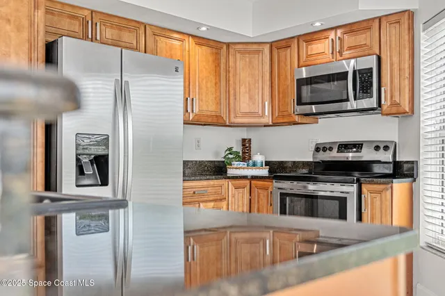 a kitchen with stainless steel appliances granite countertop a stove a sink and a microwave