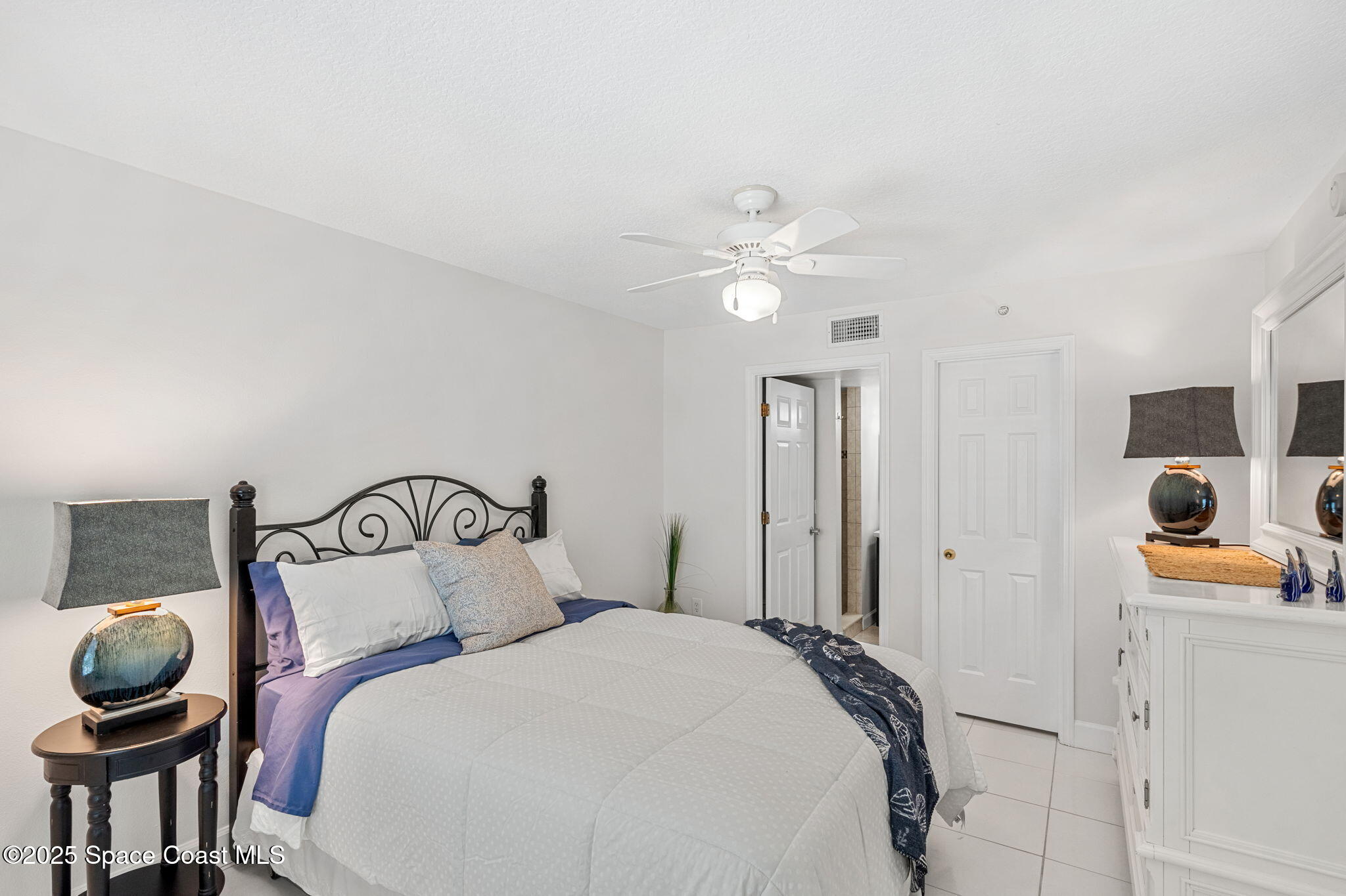 1155 South Atlantic Avenue, Unit 203 Cocoa Beach, FL 32931 - Photo 28 of 41 a bedroom with a bed and cabinets
