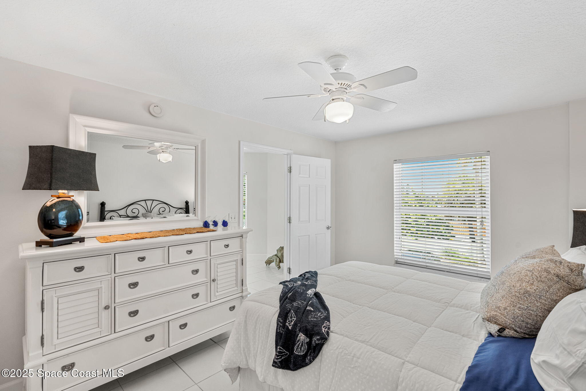 1155 South Atlantic Avenue, Unit 203 Cocoa Beach, FL 32931 - Photo 29 of 41 a bedroom with a bed and a dresser