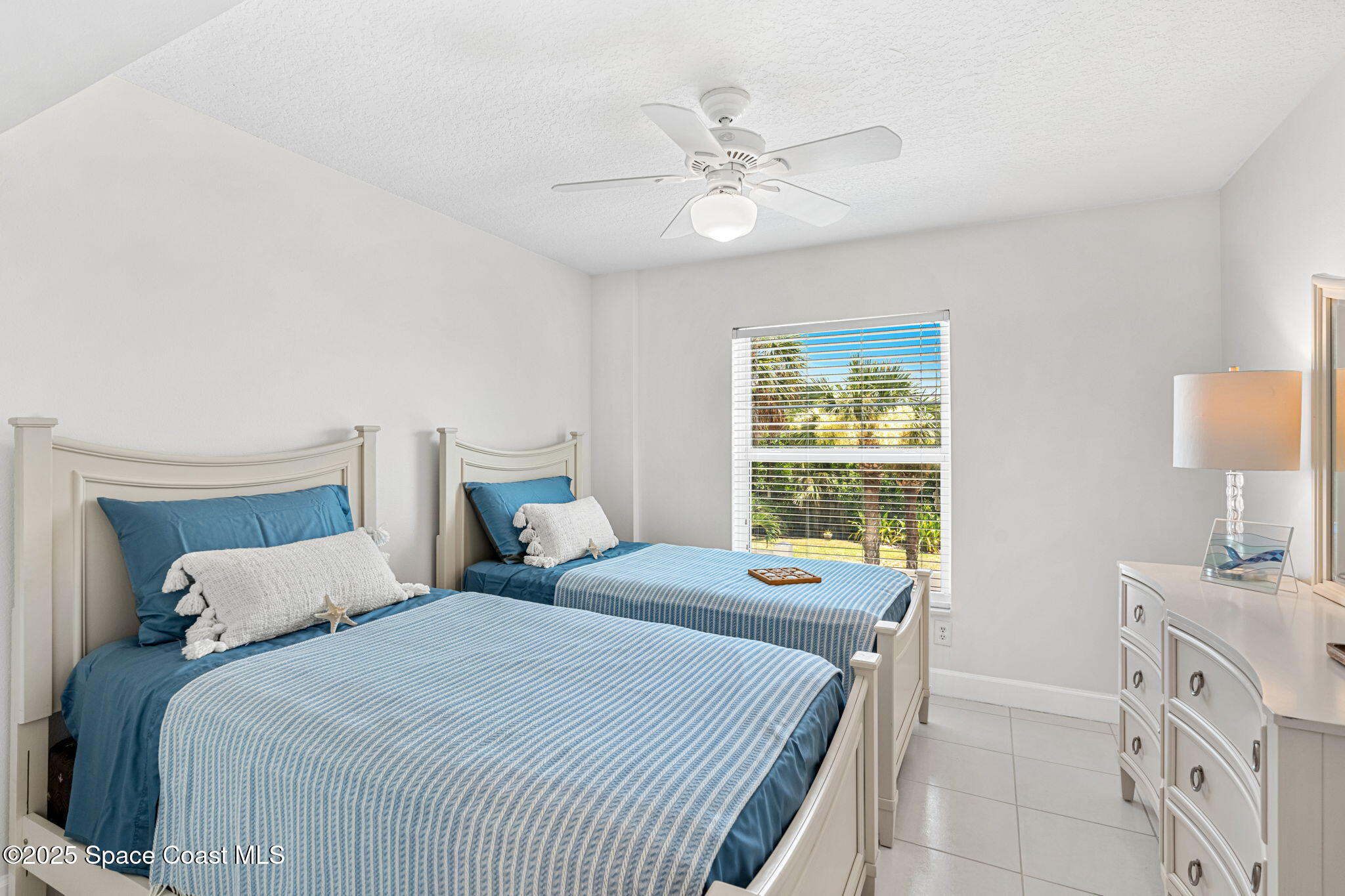 1155 South Atlantic Avenue, Unit 203 Cocoa Beach, FL 32931 - Photo 32 of 41 a bedroom with two beds and a table