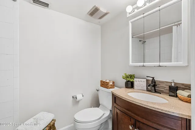 a bathroom with a granite countertop sink a toilet and mirror